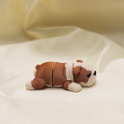 Figura de bulldog castanho e branco de plástico dividido em três partes sobre tecido branco
