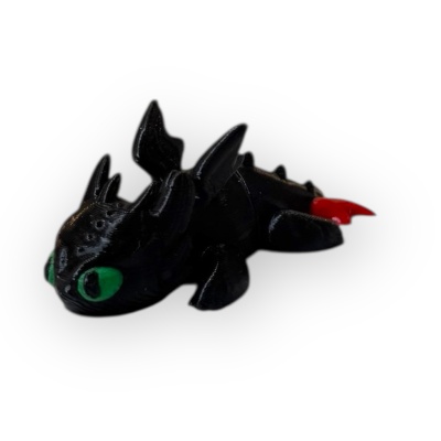 Figura de dragão preto com olhos verdes e cauda vermelha