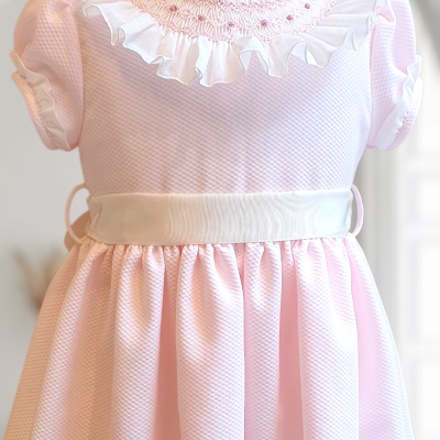 Vestido infantil cor-de-rosa com detalhes em branco e bordados na gola