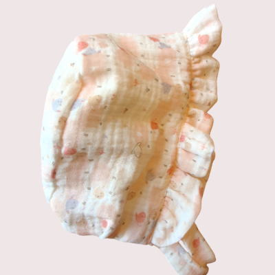 Chapéu branco de bebé com padrão de nuvens e corações em tons pastel e borda franzida