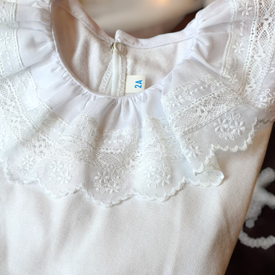 Roupa de bebé branca com gola de renda bordada floral e etiqueta 2A