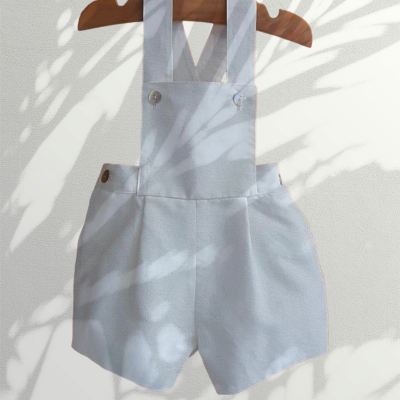 Macacão curto branco para criança com alças cruzadas e botões