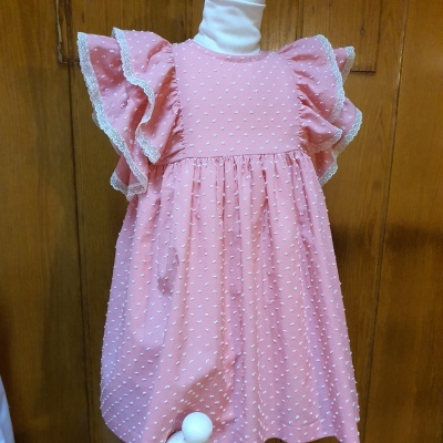 Vestido infantil rosa com pontos em relevo e mangas largas com renda branca