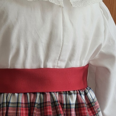 Vestido infantil branco com renda e faixa vermelha e saia xadrez colorida