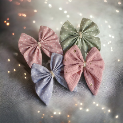 Quatro laços de tecido coloridos com padrões de bolinhas e estrelas.