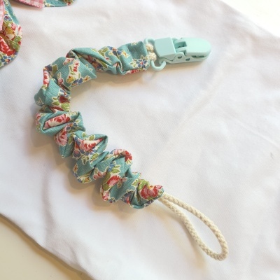 Prendedor de chucha com tecido floral e fecho verde
