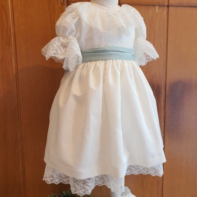 Vestido de bebé branco com renda e faixa azul claro