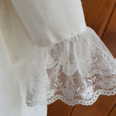 Manga branca com rendado floral e fundo de madeira