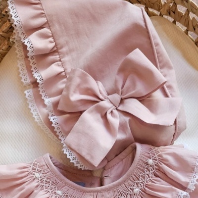 Babete e vestido rosa claro de bebé com renda branca e laço grande