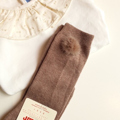 Roupa de bebé branca com gola bordada e meias castanhas com pompom