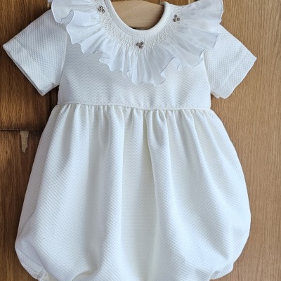 Body branco de bebé com gola de folhos e pequenas decorações prateadas