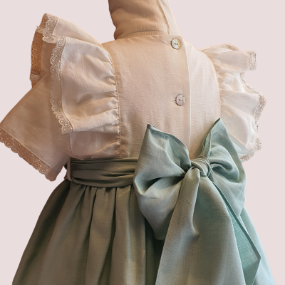 Vestido infantil bege claro com mangas com renda e saia verde-água com laço grande