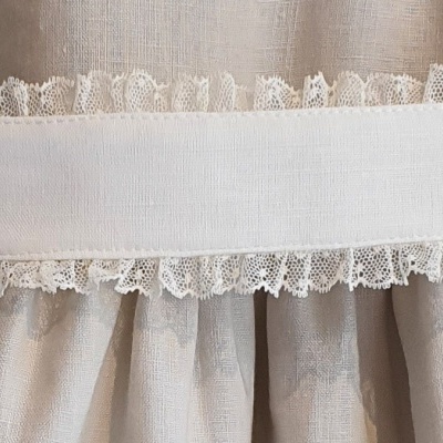 Vestido bege com cinto branco e rendas em madeira clara