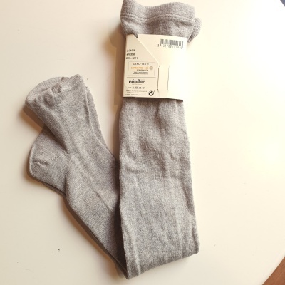 Par de meias cinza claro com etiqueta branca numa superfície branca