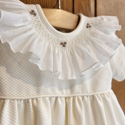 Vestido branco infantil com gola bordada e padrão discreto