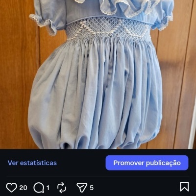 Vestido azul claro para bebé com folhos e rendas em fundo de madeira