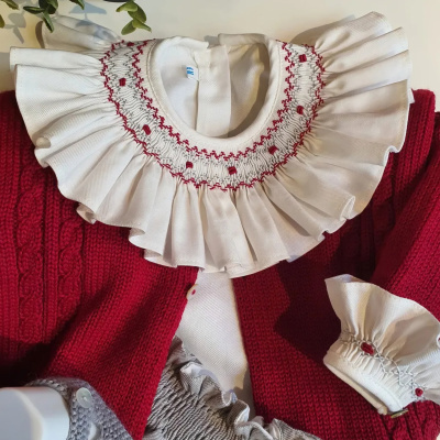 Vestido branco com gola e punhos bordados e casaco vermelho de malha