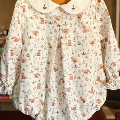 Body de bebé branco com padrão de raposas e folhas