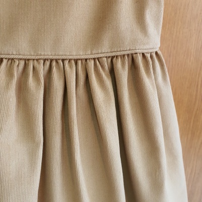 Vestido bege canelado com franzidos pendurado