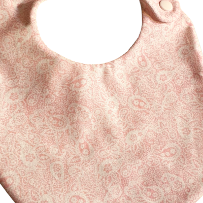 Babete rosa claro com padrão de gotas e fecho de mola branco