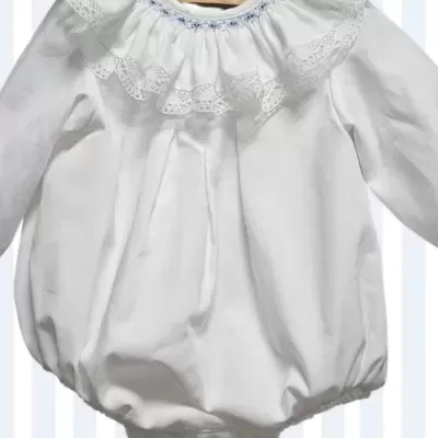 Babygrow branco com gola laceada e bordado azul pendurado num cabide