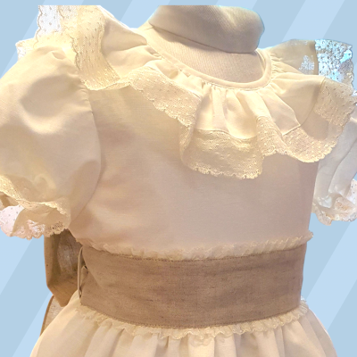 Vestido branco infantil com renda e faixa cinza num manequim