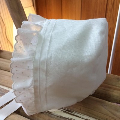 Touca branca com folhos de renda em madeira clara