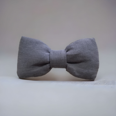 Laço cinzento em tecido texturado sobre superfície branca com padrão riscado