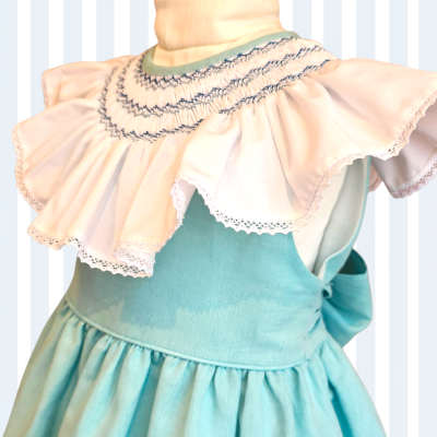 vestido infantil azul turquesa com folhos brancos e bordados azuis