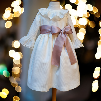 Vestido branco infantil com babados e faixa rosa em manequim