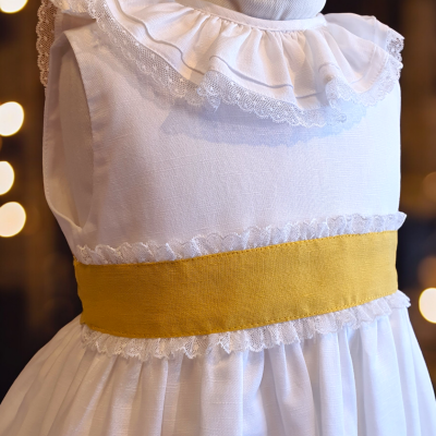 Vestido branco infantil com gola de renda e faixa amarela na cintura