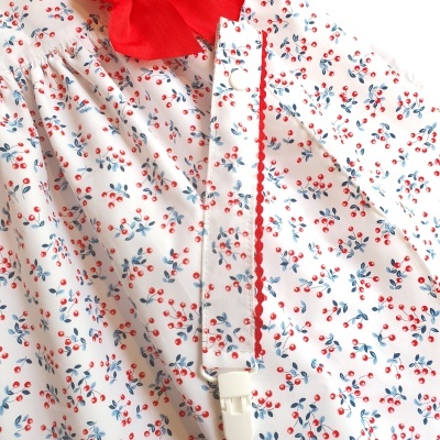 Blusa branca com padrão floral e detalhe vermelho na gola