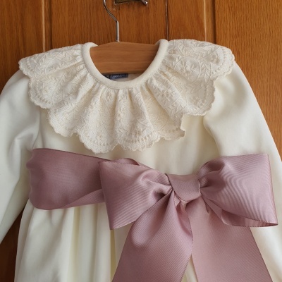 Vestido branco de bebé com gola de renda e laço rosa grande
