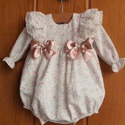 Pelele de bebé com estampa floral rosa, folhos brancos e laços de cetim rosa