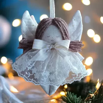 Anjo decorativo branco com vestido de renda pendurado