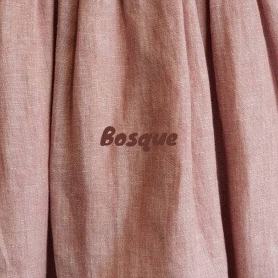 Tecido cor de rosa em linho com a palavra Bosque impressa no centro.