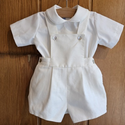 Conjunto de roupa para bebé branco com camisa e calção de linho pendurado em cabide