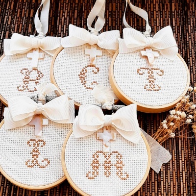 Cinco aros de bordado com letras bordadas e laços brancos
