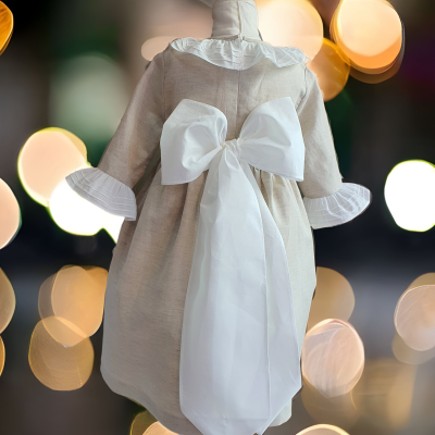Vestido infantil bege com laço branco grande atrás