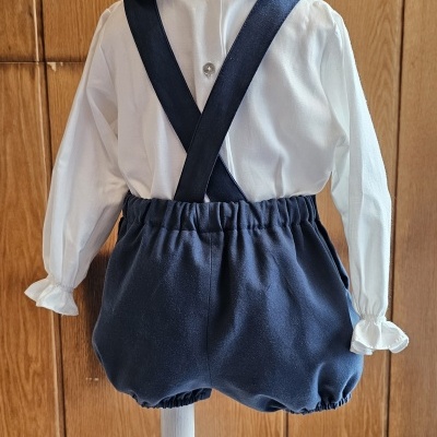 Conjunto infantil com camisa branca e calção azul com alças cruzadas