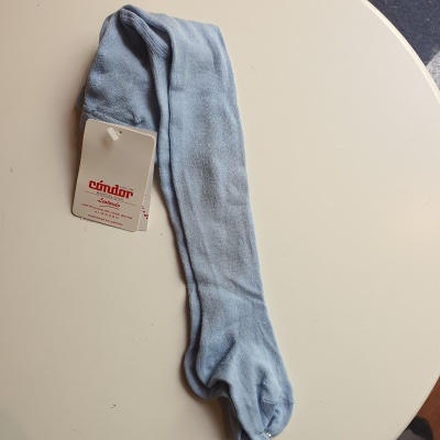 Collant azul claro com etiqueta cóndor em superfície branca redonda