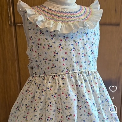 Vestido infantil branco com padrão floral e gola alta com babado colorido