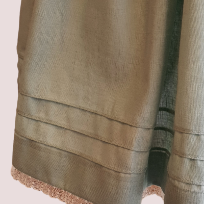 tecido verde-acinzentado com bainha em renda bege e dobras horizontais