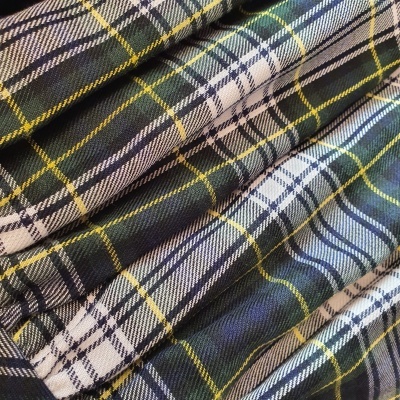 Tecido dobrado com padrão às filas em verde, branco, azul, roxo escuro e amarelo