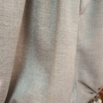 Tecido bege claro com padrão de sarja e tecido cinza ao fundo