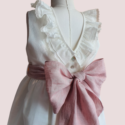 Vestido branco com gola de folhos e cinto rosa com laço grande