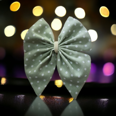 Laço verde claro com bolinhas brancas em fundo com luzes desfocadas