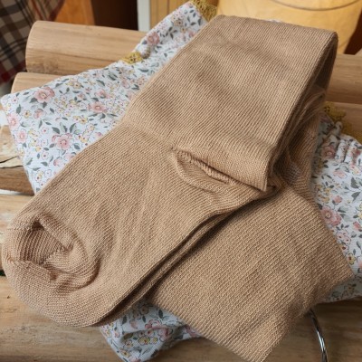 Meias castanho claro sobre bolsa de pano com padrão floral