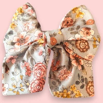 Laço de tecido floral colorido sobre fundo rosa