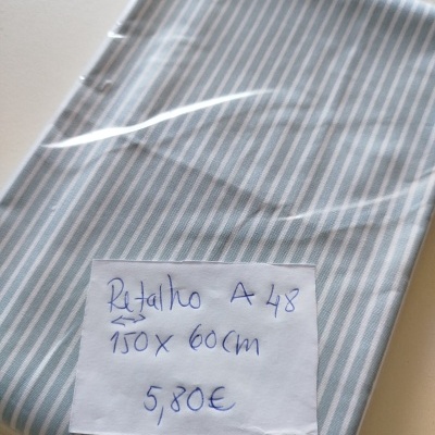 Tecido riscado azul claro e branco embalado com etiqueta manuscrita